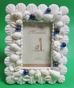 a white frame with shells and blue beads