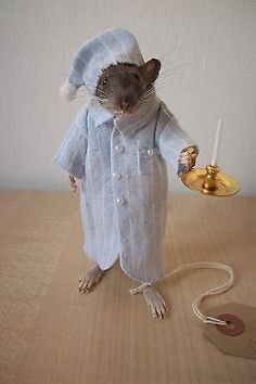 a mouse with a hat and coat holding a lamp