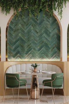 a table with two chairs and a vase on it in front of a green wall