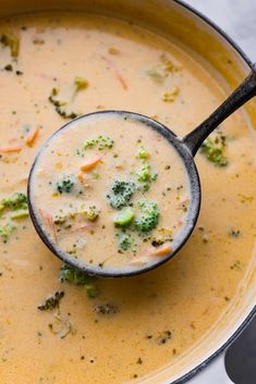 a ladle filled with broccoli and cheese soup