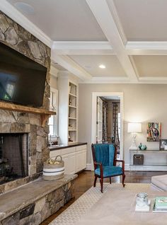 a living room filled with furniture and a flat screen tv mounted on a wall above a fireplace