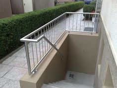 the stairs lead up to an apartment building with metal railings and handrails