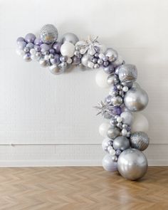 an arch made out of silver and white balloons