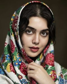 a woman wearing a colorful shawl poses for the camera