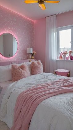 a bedroom decorated in pink and white with a large mirror on the wall above the bed