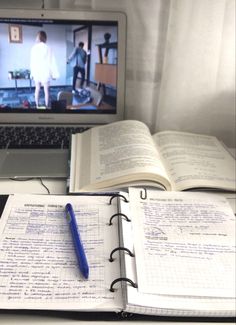 an open notebook sitting next to a laptop computer