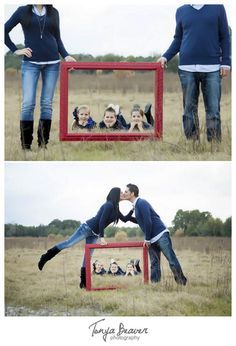 two people are standing in front of a red frame with their hands on each other