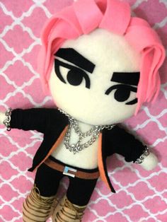 a stuffed doll with pink hair and black pants