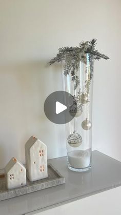 a vase filled with ornaments sitting on top of a counter next to a white house