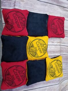 four red and yellow cushions sitting on top of a wooden table next to each other