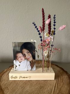 a wooden stand with flowers and a photo on it