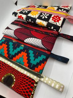 The quilted pouch highlights the beauty of African wax prints, paired with other bold and bright colors and prints. The zipper is in the middle and the pouch opens up - perfect for makeup brushes, markers or other art supplies, small toys, or anything else you can think of! The handle is sewn into the side so you can hook it onto something and make sure it doesn't get lost in your bag.  The pouch measures 6x9 inches with a 3in loop. Quilted Pouch, Sleeve Holders, Candy Cane Wreath, Small Toys, Bag Ideas, African Wax Print, Toiletry Storage, Wax Print, Mambo