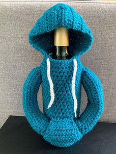 a crocheted bottle holder with a wine bottle in the shape of a hoodie