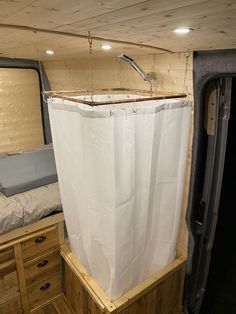 the inside of an rv with a bed and curtains