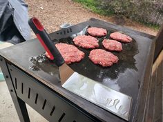 hamburger patties being cooked on an outdoor grill