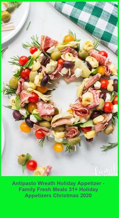 an appetizer christmas wreath made out of meats, olives and tomatoes