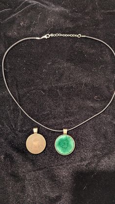 Hand-crafted Round Necklace with specially formulated sparkly Green resin. The leather cord adjusts is approximately 18" inches with 2" extender chain. The pendant is slightly larger than a quarter.  Ships in a black velvet bag. Adjustable Medallion Necklace With Lobster Clasp, Adjustable Round Pendant Necklace, Cadmium-free, Adjustable Round Pendant Necklace Cadmium-free, Cadmium-free Adjustable Round Pendant Necklace, Round Necklace, Resin Necklace, Velvet Bag, Leather Cord, Black Velvet