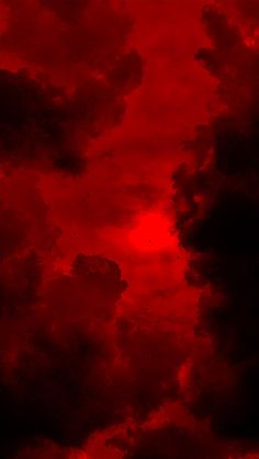 the sky is red and black with some clouds