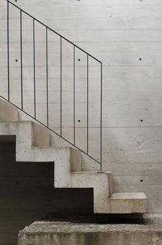 the stairs are made of concrete and have metal railings