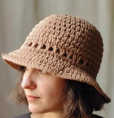 a woman wearing a crocheted hat with holes on the brim and side