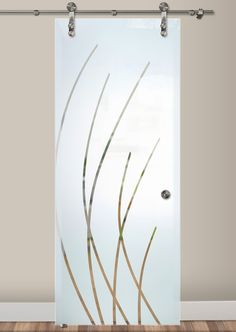 a glass door with some plants on it in front of a white wall and wood floor