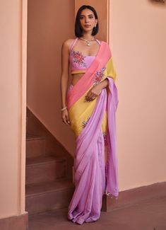 Introducing the stunning Multi Colour Embroidered Crepe Saree with Halter Blouse, crafted from luxurious crepe fabric. The multi colour saree features a vibrant blend of pastel hues – soft pink, sunny yellow, and lilac – creating a harmonious and eye-catching palette. The saree drapes beautifully for a sophisticated look and is adorned with intricate 3D embroidered floral bootas, adding a touch of elegance and charm to the ensemble. Paired with an embroidered halter blouse, this outfit perfectly balances traditional craftsmanship with contemporary design. Perfect for daytime events, cultural gatherings, and festive celebrations, this outfit effortlessly combines tradition with modern aesthetics. Composition : Saree - Crepe, Blouse - Silk, Underskirt - Satin Care: Dry Clean Only and Vacuum Designer Wear Pink Embroidered Pre-draped Saree, Designer Embroidered Pink Pre-draped Saree, Designer Pink Embroidered Pre-draped Saree, Festive Pink Pre-draped Saree With Floral Embroidery, Multicolor Georgette Blouse Piece With Floral Embroidery, Traditional Pink Pre-draped Saree With Floral Embroidery, Traditional Pink Floral Embroidered Pre-draped Saree, Multicolor Georgette Blouse With Resham Embroidery, Pink Georgette Blouse With Floral Embroidery