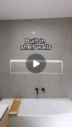 a white bath tub sitting next to a wooden cabinet in a bathroom with the words built in shelf walls above it