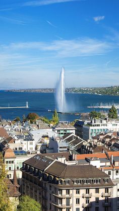 an aerial view of a city with water spouting from the top and buildings below