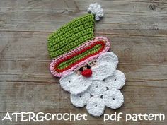 a crocheted santa clause with a green hat