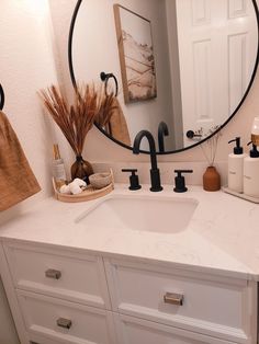 a bathroom sink with a round mirror above it