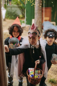 three children dressed up in costumes and holding buckets with halloween activities written on them