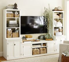 a living room filled with furniture and a flat screen tv on top of a white entertainment center