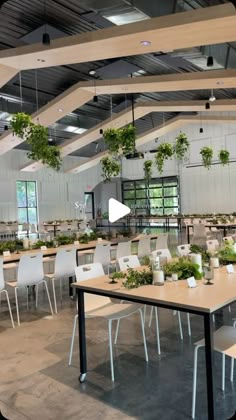 a room filled with lots of tables and chairs covered in green plants on top of them