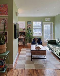 a living room filled with furniture and a flat screen tv on top of a wooden table