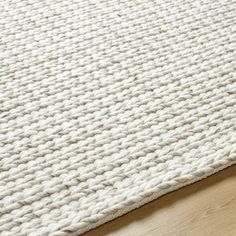 a white rug on top of a wooden floor