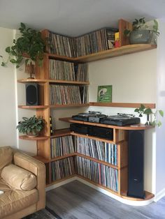 a living room filled with lots of books and vinyl record player on top of a wooden shelf