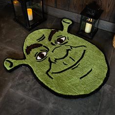 a green rug with an image of a cartoon character on it and two lanterns in the background