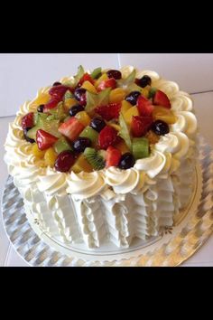 a white cake topped with fruit on top of a table