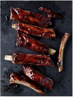 barbecue ribs with bbq sauce and onions on a slate board, ready to be grilled