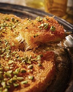 a close up of a pizza on a pan with pistachios sprinkled on it