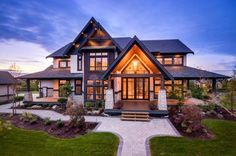 a large house with lots of windows on the front and side of it at dusk