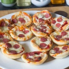 mini pizzas are arranged on a plate with cheese and pepperoni toppings, ready to be eaten