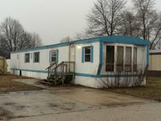 an old mobile home with blue trim and windows