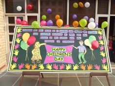 a children's day sign in front of a building with balloons and streamers