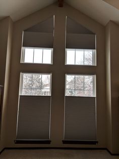 three windows with blind shades in a room