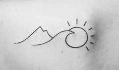 a small sun and mountain tattoo on the back of a woman's shoulder