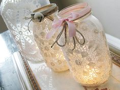 two mason jars with lace doily on them