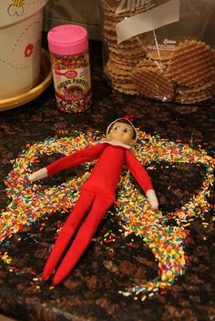 an elf is laying on the counter with sprinkles