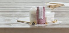 two bottles of lotion sitting on top of a wooden table