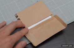 someone is cutting out a piece of cardboard with scissors